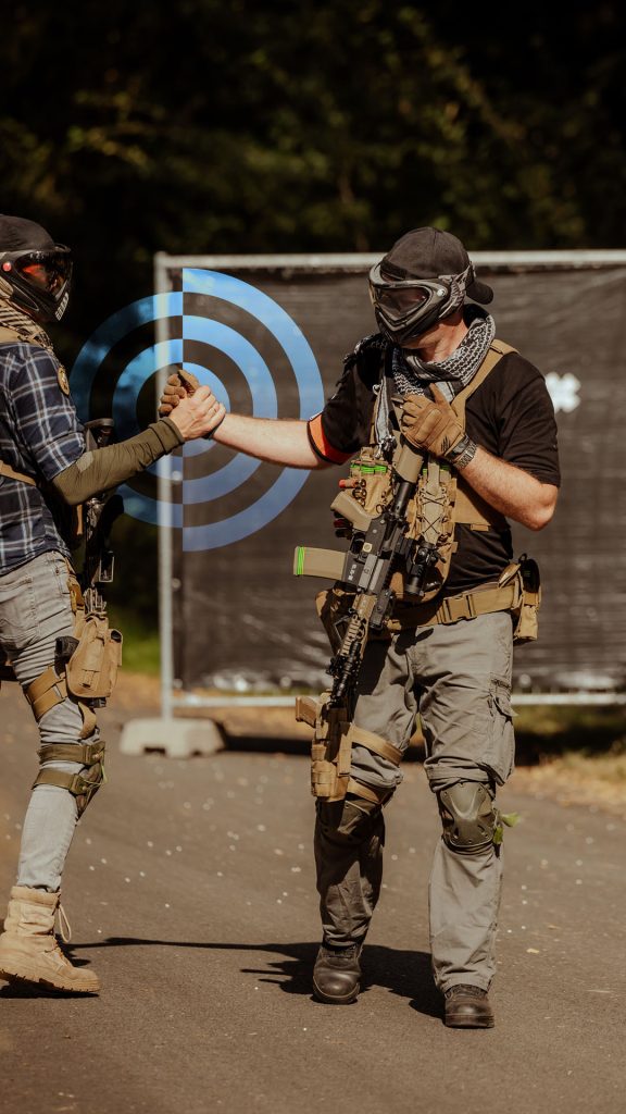 Twee airsofters op een buitenlocatie die elkaar de hand schudden